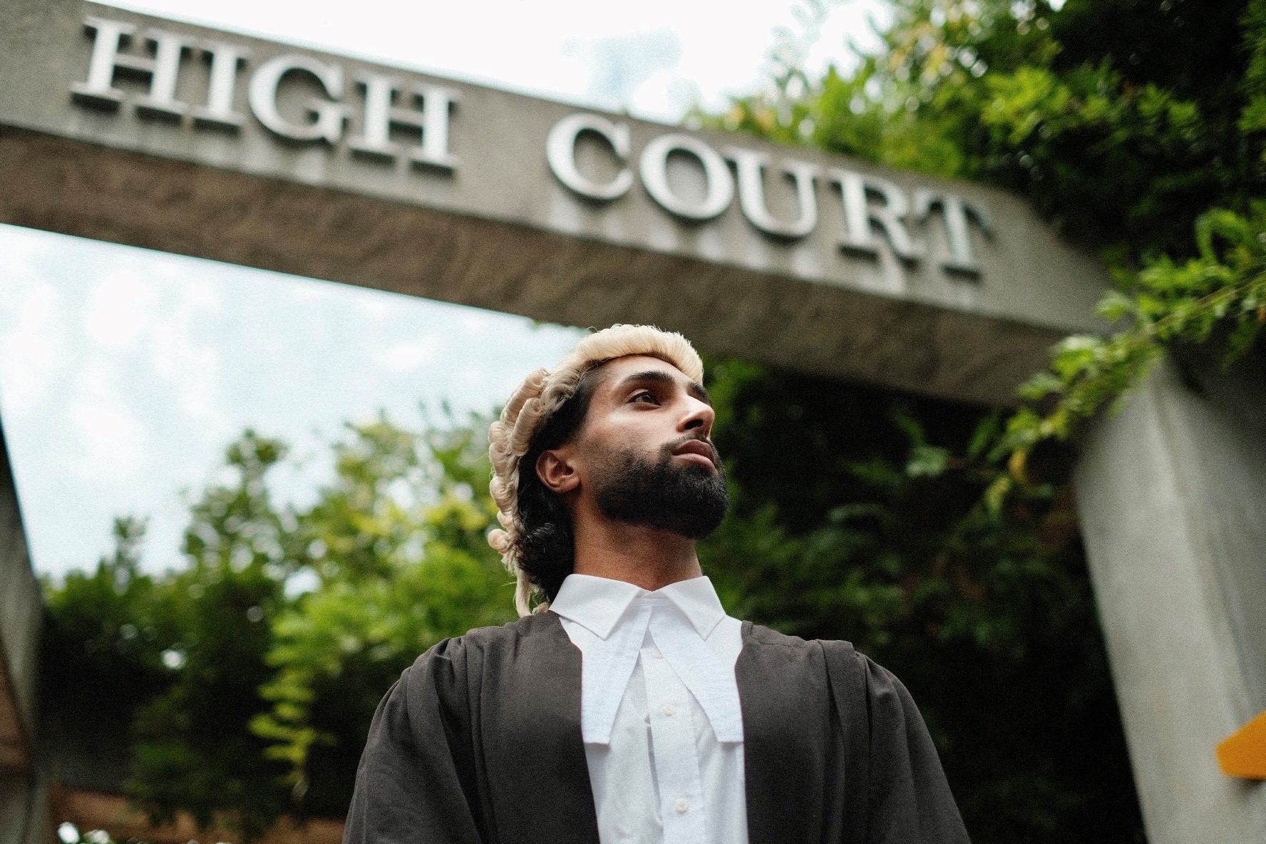 Dilworth Alumni on Graduation Day standing beneath the Auckland High Court sign