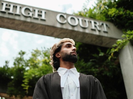 Dilworth Alumni on Graduation Day standing beneath the Auckland High Court sign