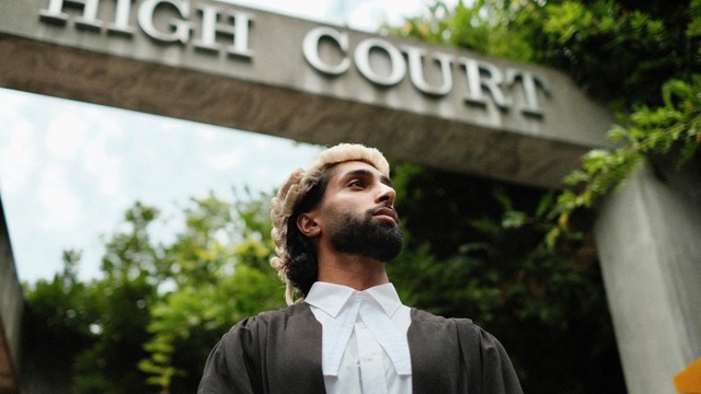 Dilworth Alumni on Graduation Day standing beneath the Auckland High Court sign