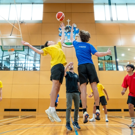 boys playing basketball, jumping to catch the ball