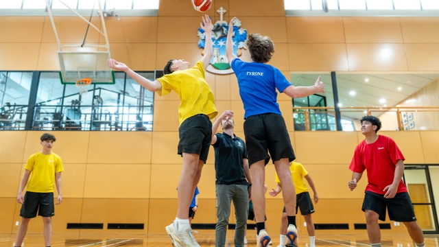 boys playing basketball, jumping to catch the ball