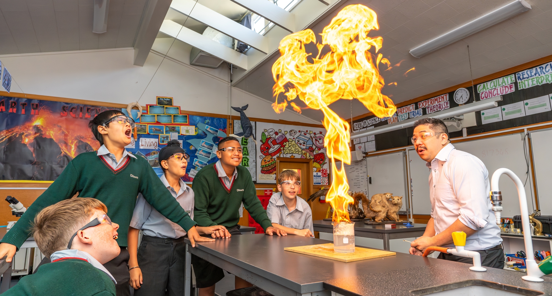 boys and teacher doing an experiment in science class 