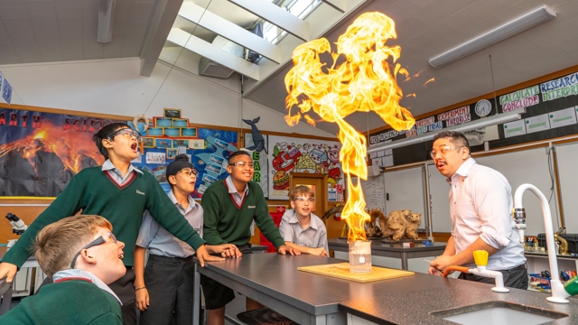 boys and teacher doing an experiment in science class 