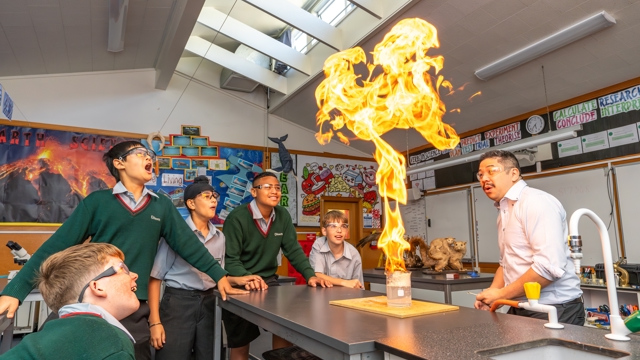 boys and teacher doing an experiment in science class 