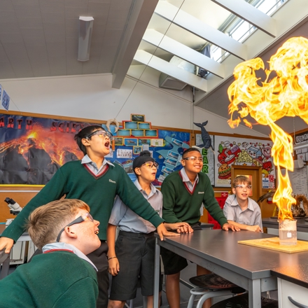 boys and teacher doing an experiment in science class 