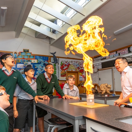 boys and teacher doing an experiment in science class 