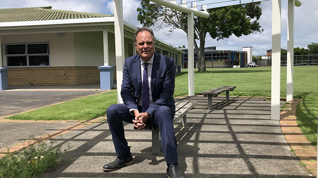 Former Head of Junior Campus sitting on a bench seat at the Junior Campus 