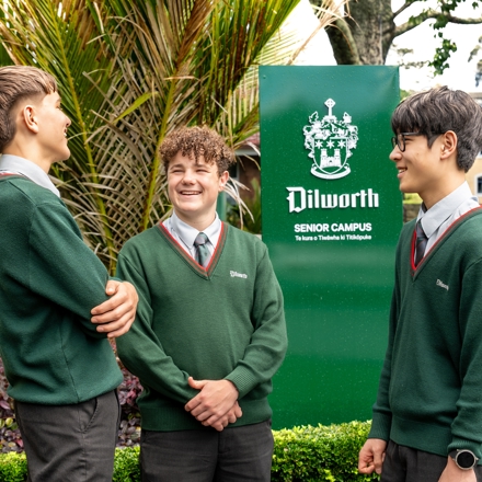 boys standing and talking by the Dilworth sign